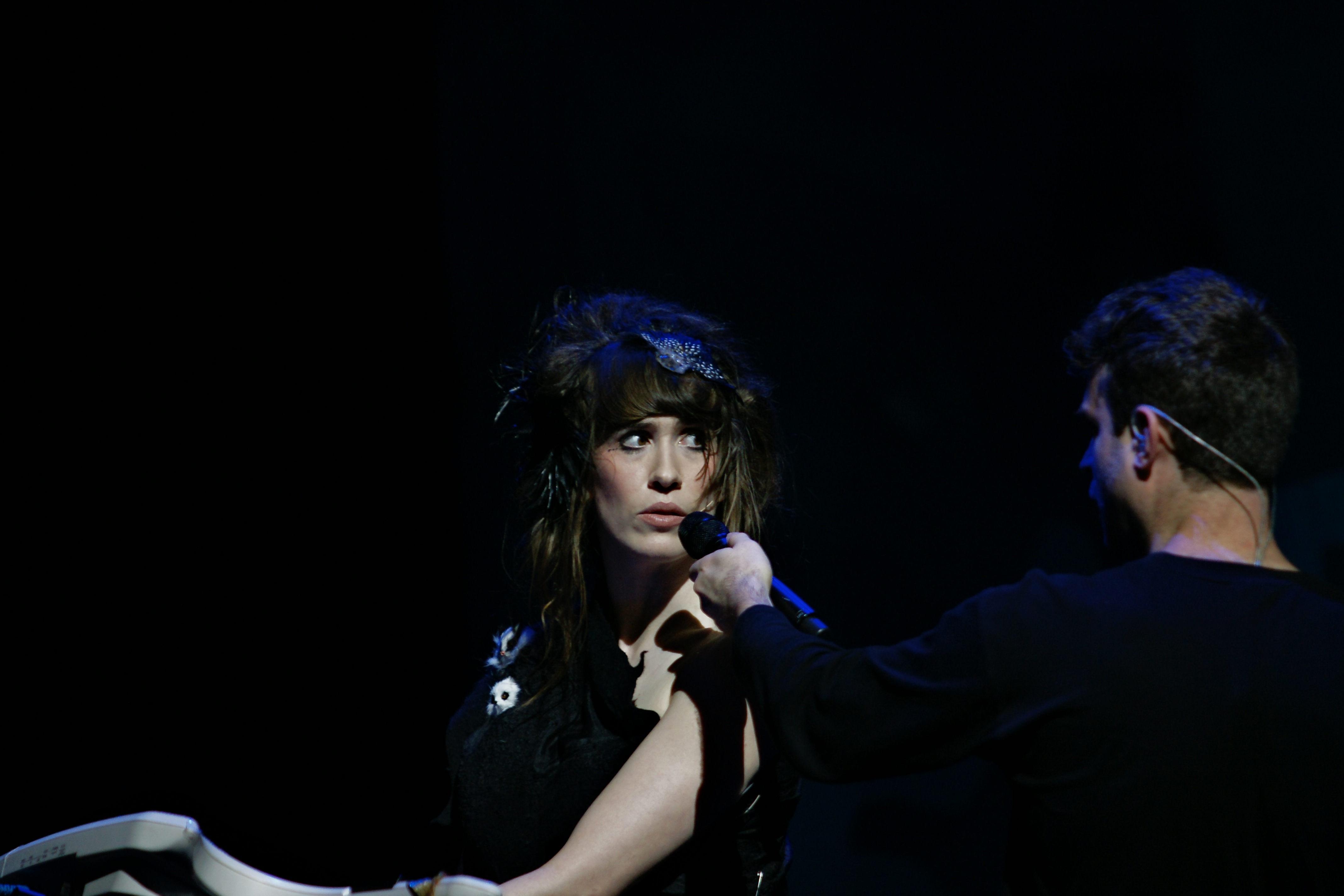 Imogen Heap staring at man holding microphone up to her